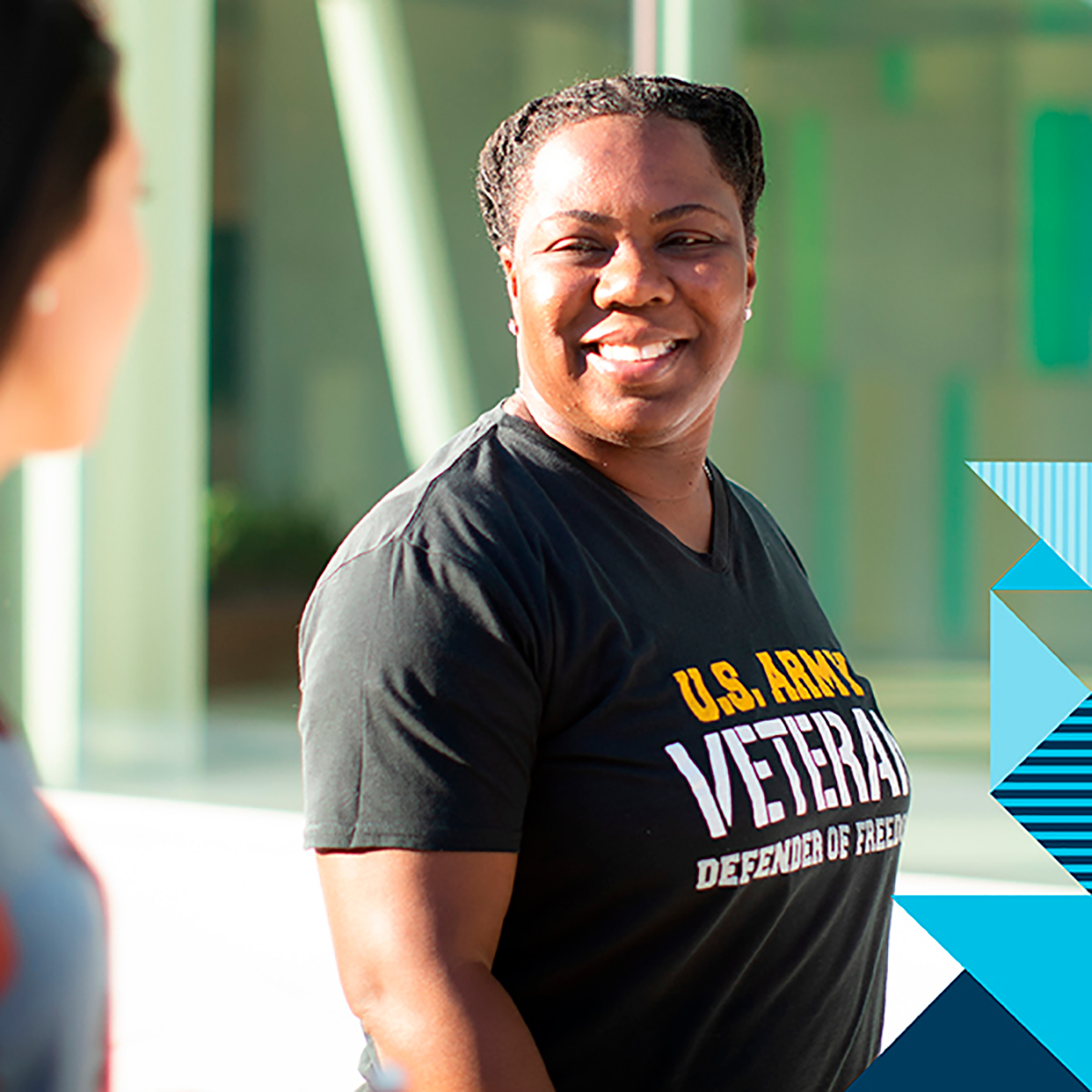 Capital One veteran associate stands and smiles, wearing a U.S. Army Veteran t-shirt